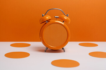 Orange alarm clock on color background. Trendy minimalist style. Time, business and technology...