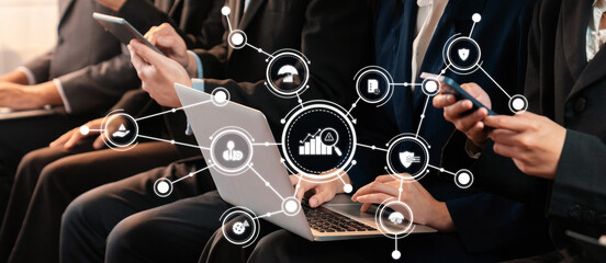 A professional team engages in collaborative tasks using digital devices in a modern office setting, enhancing their management strategies and decision-making processes. Amity