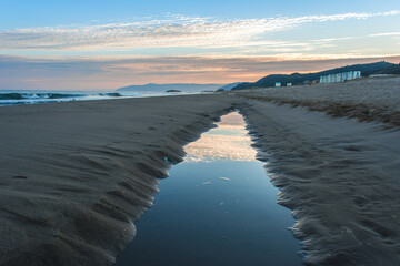 Wave sea beach and sunset sky abstract background. Nature and summer concept. Summer background, warm beach view with sunset, calm waves and sun rays reflecting on sea surface. vacation concept.
