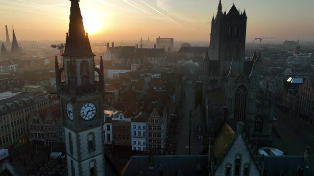 orbiting shot of Ghent old town aerial view at sunrise, tourist destination in Belgium, drone shot of Belgian medieval town of Ghent with gothic cathedrals in the morning