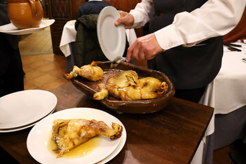 Waiter serving roast suckling pig in a restaurant in Segovia city