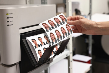 Worker with passport photos of women near modern printer indoors, closeup