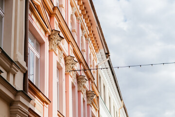 A charming European street lined with pastel-colored historic buildings, ornate architectural details, and a nostalgic atmosphere under a soft daylight sky