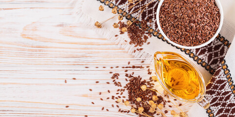 Brown linen seeds, flaxseed vegetable oil on white rustic wooden background. Healthy super food...