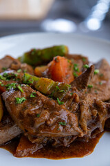 A plate of meat with Potato and herbs