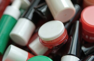 Heap of colorful cosmetic bottles with creams, lotions. Close-up of beauty products containers. Skincare, makeup, body care products. Beauty industry packaging, container product, beauty routine