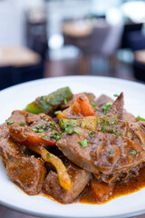 A plate of meat with Potato and herbs