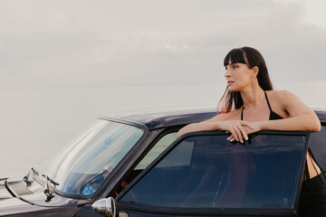 Beautiful girl near a black car