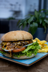 A burger with lettuce and tomato on a blue plate