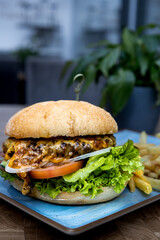 A burger with lettuce and tomato on a blue plate