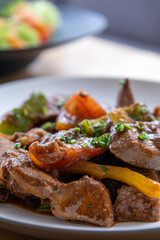 A plate of meat with Potato and herbs