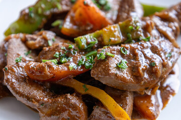 A plate of meat with Potato and herbs
