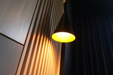 The stylishly lit bedside wall lamp in the room creates an aesthetic atmosphere in the interior of...