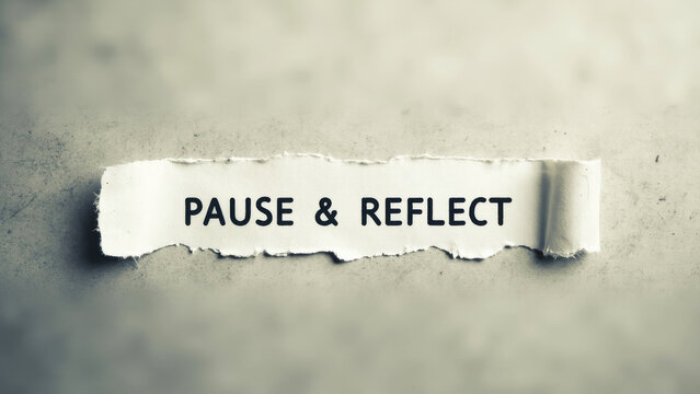 Torn paper displaying pause and reflect words, symbolizing personal mindfulness and quiet contemplation moments