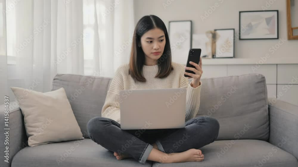 Poster a person sitting on a couch holding a cell phone, possibly checking messages or making a call.