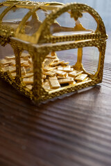 Mini treasure chest with gold bars inside in close-up