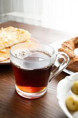 Local Turkish breakfast table Turkish tea, su boregi, green olives and simit bagel