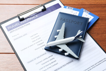 Medical tourism. Travel insurance application form, passport with tickets and airplane model on...