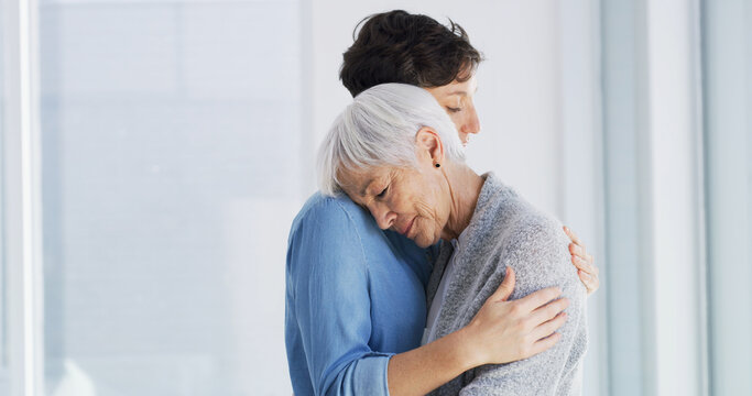 Sad, comfort and woman hugging senior mother in retirement home for grief, support or loss. Emotional, love and female person embracing elderly mom for empathy, care and emotions in nursing facility.