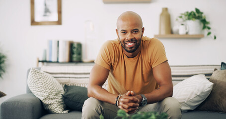 Man, portrait and smile in home with relax, weekend break and chill on sofa. African person, happy...