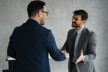 Two businessmen shaking hands at office
