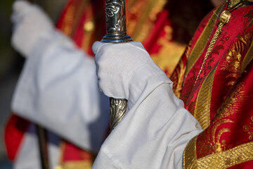Altar boy in Holy Thursday procession attire carrying a banner in the city of Murcia, Spain