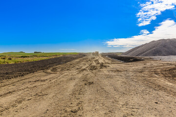 Dirt road with a truck driving down it
