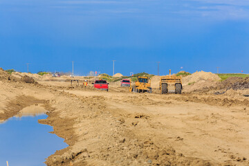 Construction site with a lot of dirt and a few cars