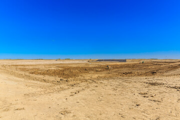 Barren desert landscape with a blue sky in the background