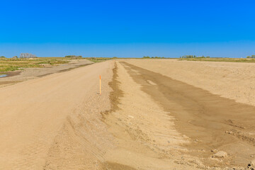 Dirt road with a pole in the middle of it