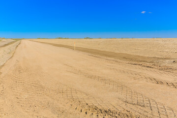 Dry, dusty road with a blue sky in the background