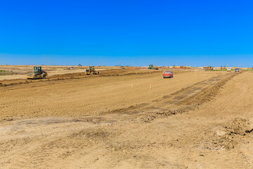 Construction site with a red truck driving down a dirt road