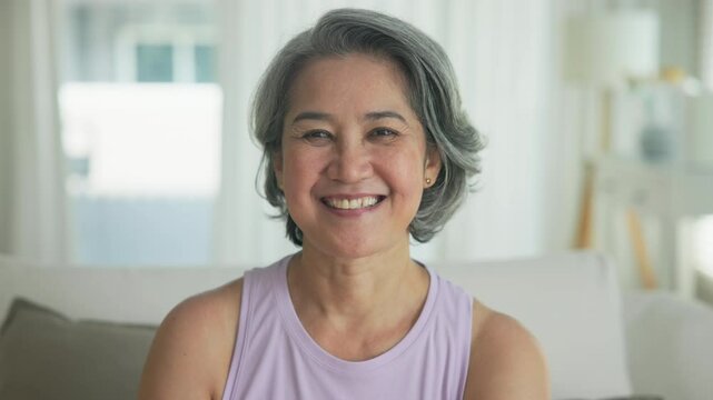 Asia adult active aged people middle age grey hair mom old female joy smile front view look at camera happy face mental health care sit relax at home sofa elder aging life asian single mum parent day.