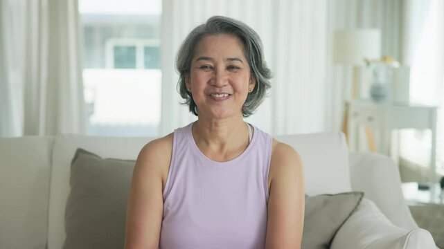 Asia adult active aged people middle age grey hair mom old female joy smile front view look at camera happy face mental health care sit relax at home sofa elder aging life asian single mum parent day.