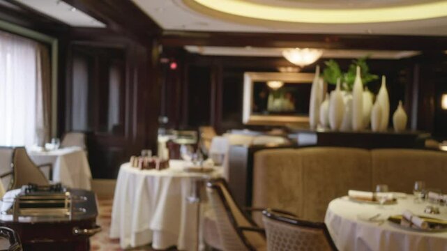Luxury restaurant interior defocused with elegant table settings wooden decor and soft lighting creating a bokeh effect in a relaxed and refined atmosphere indoors.