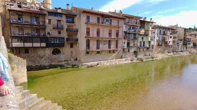 Tourist woman contemplating the river that crosses the medieval city of Valderrobres, Teruel.