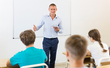 Male speaker giving lesson for teenage students in classroom