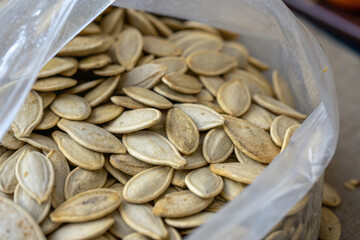 The white pumpkin background shows a bag of pumpkin seeds