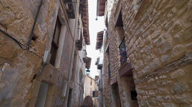 Tourist woman walking through the picturesque alleys of the medieval village of Valderrobres, Teruel.
