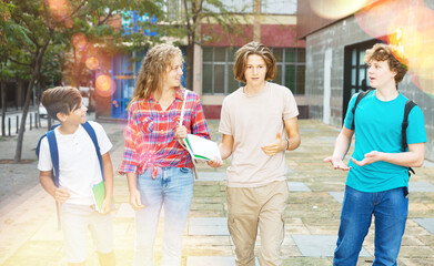 Teenagers students of middle school chatting and spending happy time together outside