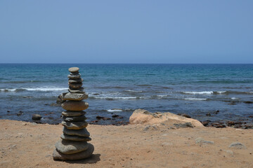 Pebble tower - balance harmony. Stones arranged in a pyramid on the coast of the sea beach. Balance and philosophy of spiritual peace. Therapy, spa, summer travel vacations