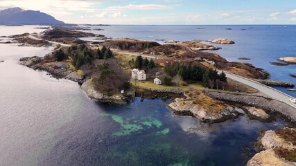 Aerial view of a white house with outbuildings beside Norway iconic Atlantic Ocean Road