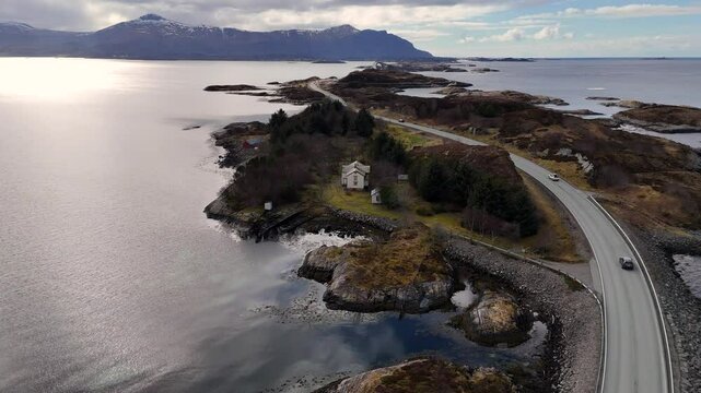 Drone view of a white house with nearby outbuildings set along Norway stunning Atlantic Ocean Road