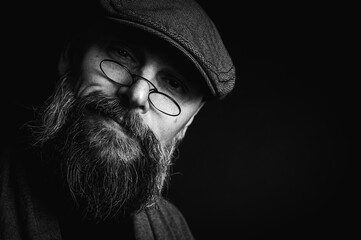 Black and white, Macro portrait of a serious bearded man in a cap and glasses on a black...