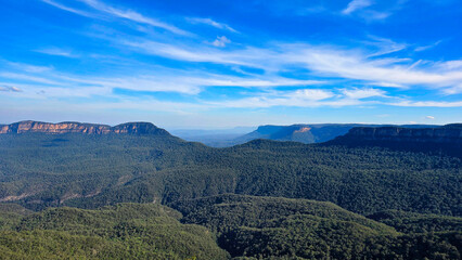Blue Mountains of New South Wales, Australia.Vast mountain landscape under a blue sky with wispy clouds in a serene afternoon setting