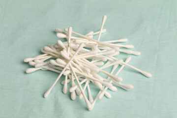 un lote de cotonitos blancos apilados desordenamente sobre una tela celeste clara