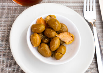Typical Spanish tapas - appetizing pickled green olives with pits and garlic