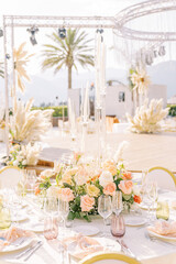 Served table with a colorful bouquet of flowers and candles in candlesticks