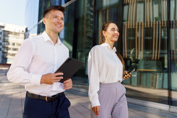 Obraz premium Colleagues Enjoying a Productive Afternoon Walk Outside a Modern Office in a Vibrant Urban Setting