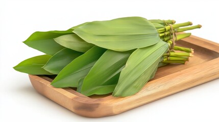 Vibrant fresh pandan leaves arranged on a wooden tray against a bright white backdrop, celebrating nature's beauty